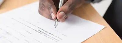 Bénéficiaire assurance vie : règles et exclusions main-signature-contrat