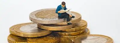 Assurance vie : investir en unités de compte figurine assis sur des pièces de monnaie